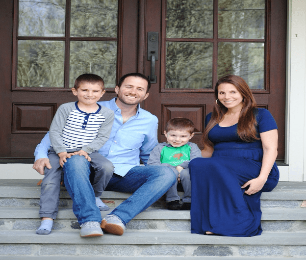 Dr. Markowitz and his family sitting on the front steps of a house